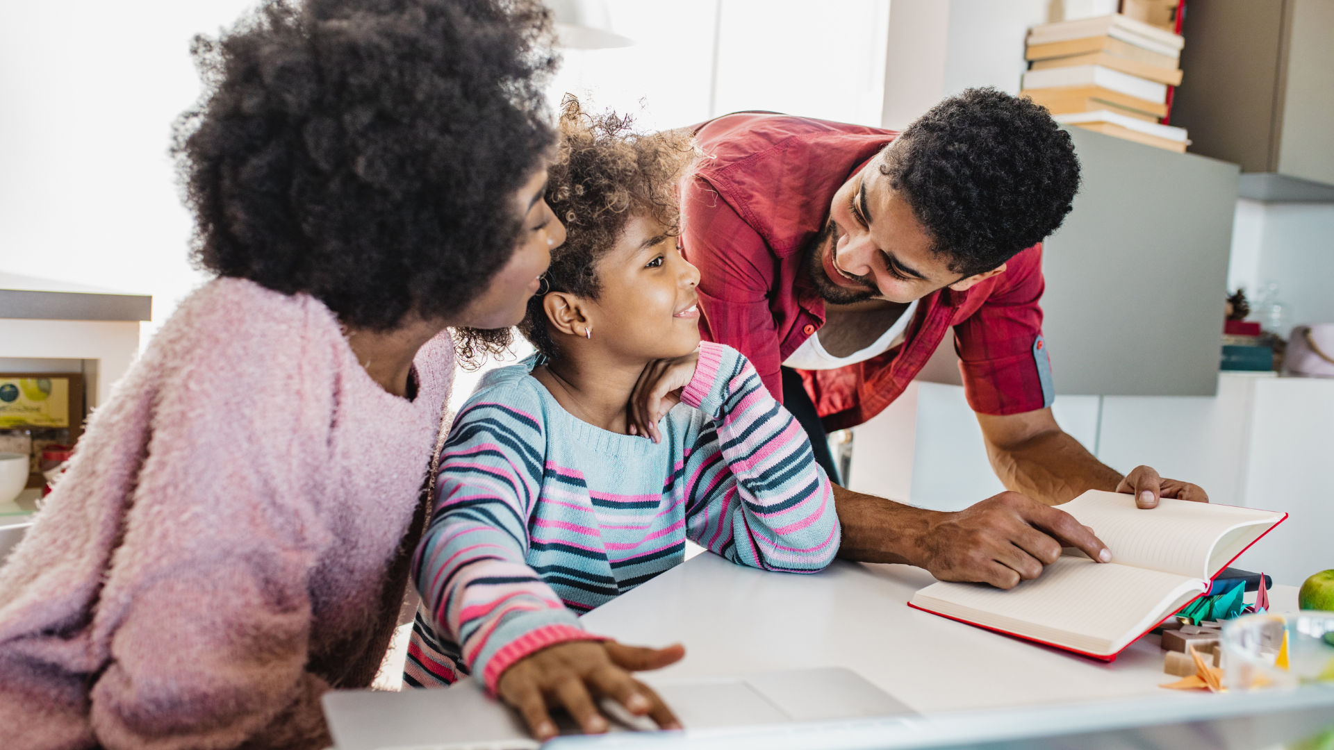 two parents happily reading with their child