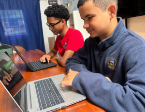 Two students at Chatmore International School working on laptops