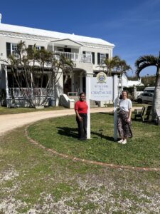 A representative from CENTURY and from Chatmore International School stand outside the school building.