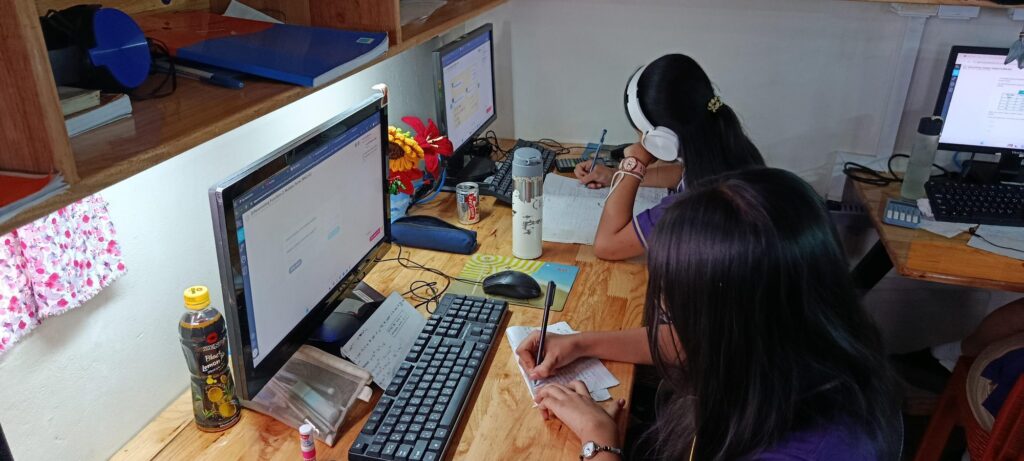 Two students at Myanmar Vision International School taking notes during a CENTURY lesson on differentiation for IGCSE maths